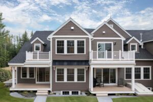 View of Green Peak Townhomes back porches with green grass and blue sky.